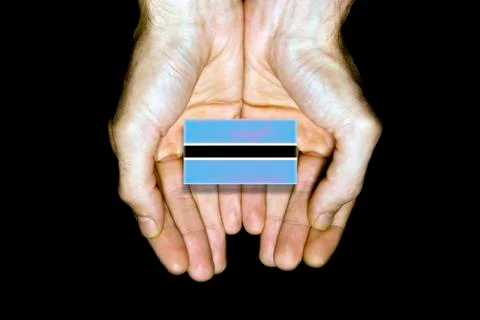 Flag of Botswana in hands on black background Stock Photos