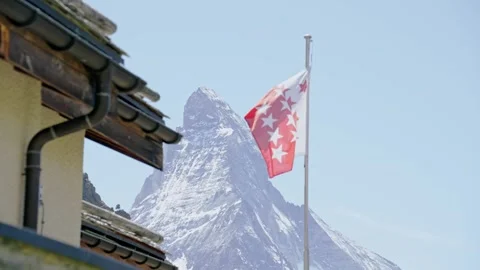 The flag of the canton of valais waving in the wind with the matterhorn Video stock 339090043