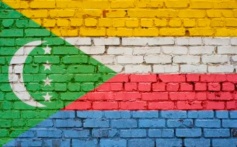 Flag of Comoros painted on brick wall, background texture Stock Photos