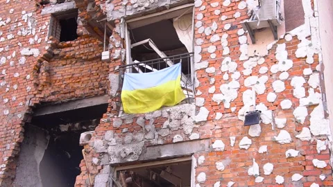 A flag is displayed on the window of a brick building Stock Footage 274572368