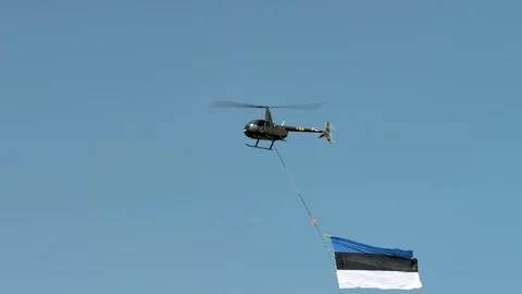 A flag of Estonia being flown by the helicopter Stock Footage 121896320