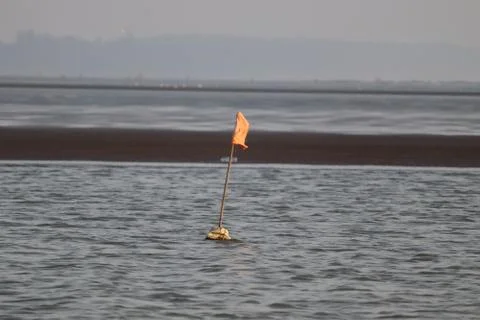 A flag floating on the sea. Oceanic waves of water. Stock Photos
