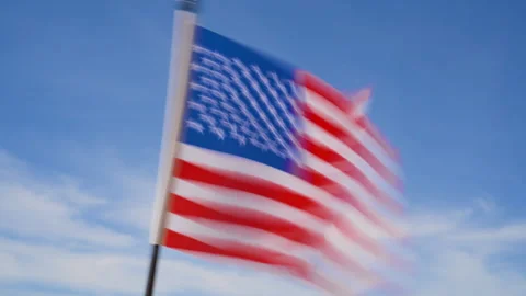 The flag is fluttering in the wind against a clear blue sky Stock Footage 276314928