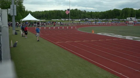 Flag flying half mast at a track and field meet Stock Footage 202092550