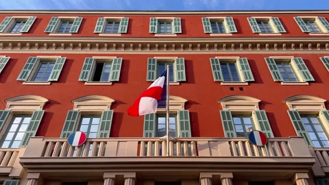The flag of France waves on the classical facade of the building at sunset Video stock 223028158