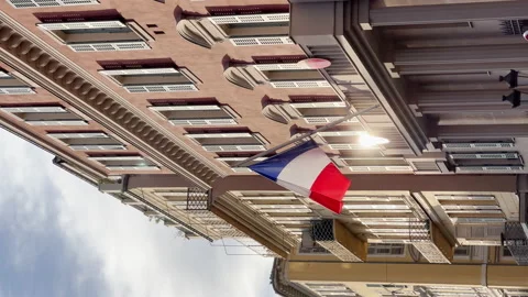 The flag of France waves on the classical facade of the building at sunset Video stock 223028402