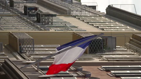 The flag of France waves on the classical facade of the building at sunset Video stock 227362281