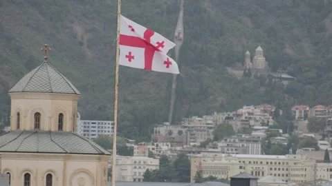 Flag of Georgia flies on background of old city in Tbilisi Stock Footage 292307128