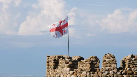 Flag of Georgia on an old tower by the blue sky Stock Footage 249895704