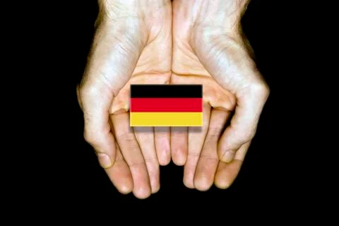 Flag of Germany in hands on black background Stock Photos
