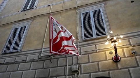 Flag of the Giraffa Contrada waving between the houses of Siena, Tuscany - Italy Video stock 83458527