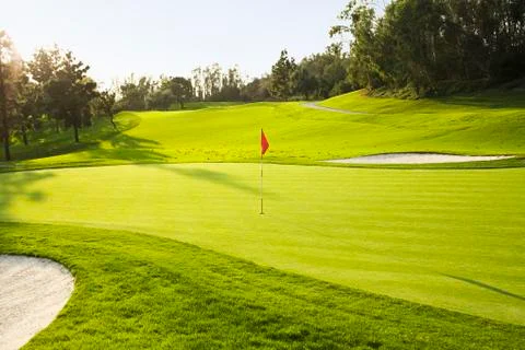 Flag on golf course surrounded by sand traps Photos