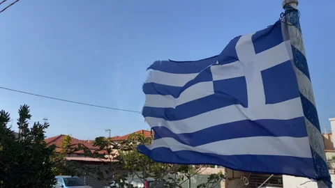 The flag of Greece is blowing in the wind on a sunny cloudless day. Aegean Sea Stock Footage 293711412