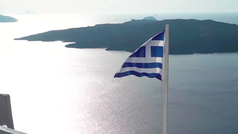 The flag of Greece is evolving on a flagpole on the island of Santorini Stock Footage 165901340