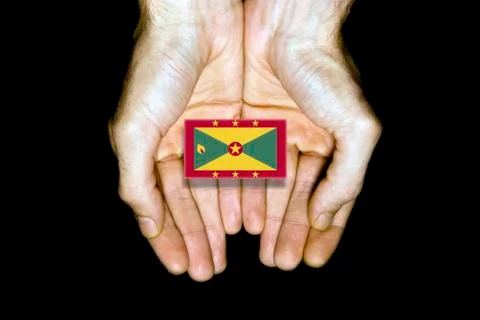 Flag of Grenada in hands on black background Stock Photos