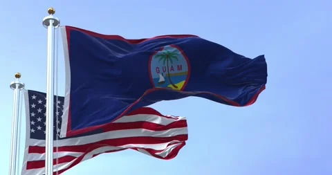 Flag of Guam waving in the wind with the US flag on a clear day Stock Footage 211812108