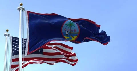 Flag of Guam waving in the wind with the US flag on a clear day Stock Illustration