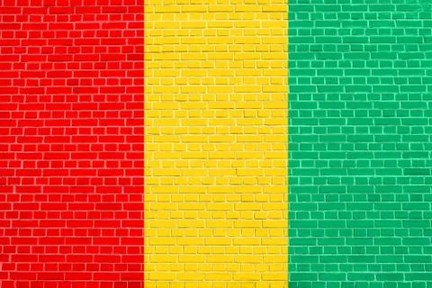 Flag of Guinea on brick wall texture background Stock Photos