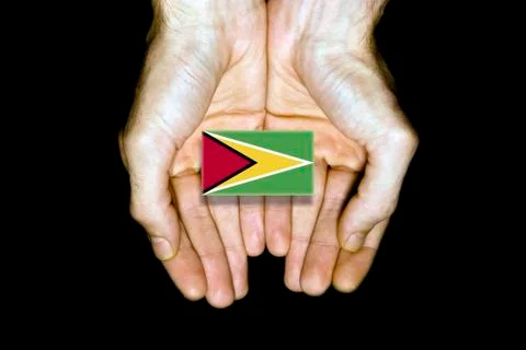 Flag of Guyana in hands on black background Stock Photos