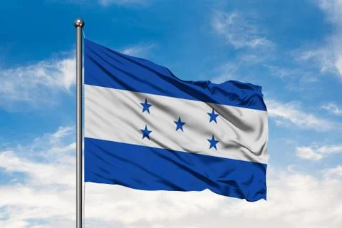 Flag of Honduras waving in the wind against white cloudy blue sky. Honduran f Stock Photos