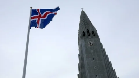 Flag of Iceland waving in wind in front of Hallgrimskirkja the symbol of Iceland Stock Footage 93219118