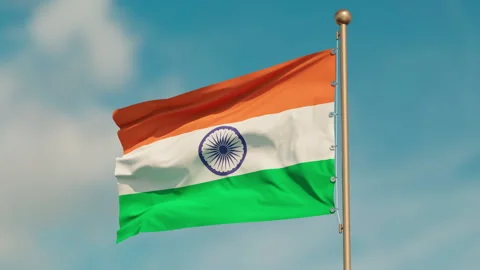 The flag of India flutters in the gentle wind. Close up. sunny day. Seamless Stock Footage 253224320