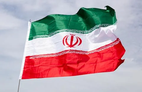 Flag of Iran waving on cloudy sky during daytime Photos