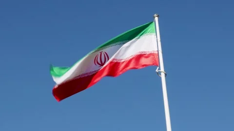 Flag of Iran waving in wind against blue sky Video stock 254272581