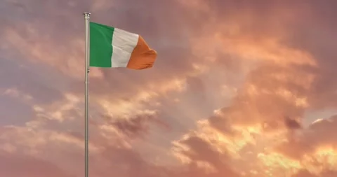 The Flag of Ireland  flies gracefully over a setting sun and its golden rays Stock Footage 240956201