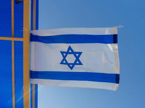 The flag of Israel flutters on a beam under the roof. Flag under the trend of Stock Photos