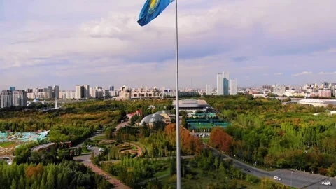 The flag of Kazakhstan flies on a flagpole in the wind in the center of Astana. Stock Footage 249952501