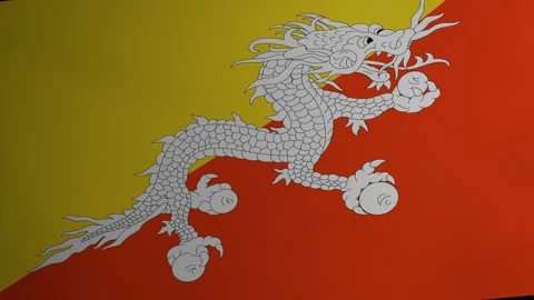 The flag of the Kingdom of Bhutan flutters in the wind. Fabric texture. South Stock Footage 241325723