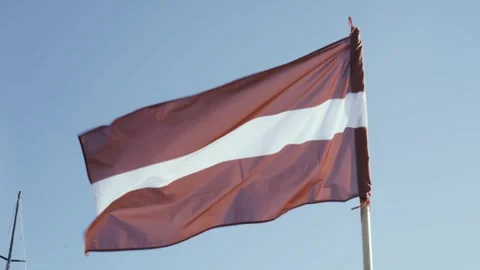 Flag of Latvia, develops against the blue sky 動画素材 250276254