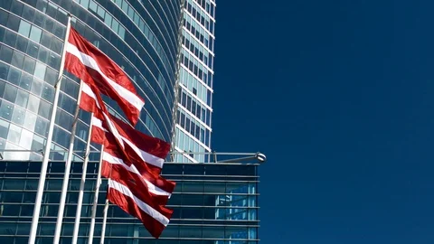 Flag of Latvia in front of an office skyscraper building on a sunny summer day 스톡 동영상 89541953