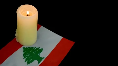 Flag of Lebanon and single burning candle on black background. Stock Footage 288859315