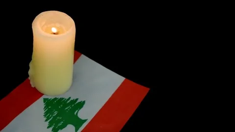 Flag of Lebanon and single burning candle on black background. Stock Footage 288860245