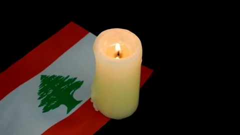 Flag of Lebanon and single burning candle Stock Footage 288860883