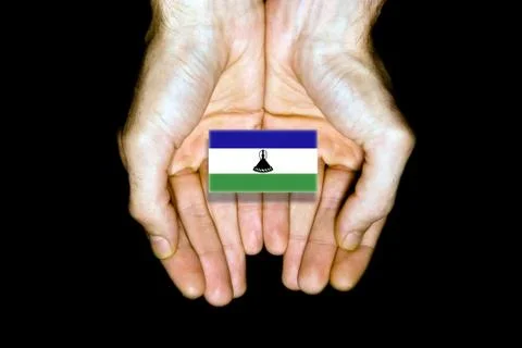 Flag of Lesotho in hands on black background Stock Photos