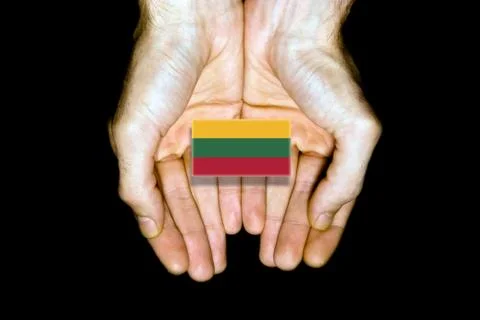 Flag of Lithuania in hands on black background Stock Photos