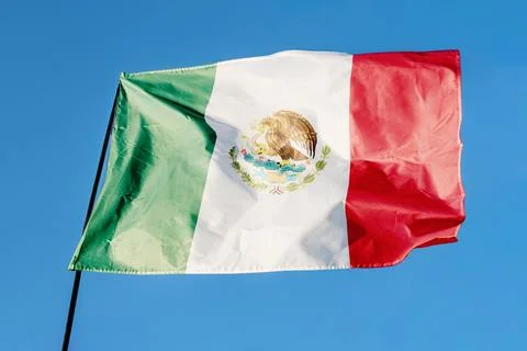 Flag of Mexico. Flag waving in the wind against a clear blue sky, fluttering  Stock Photos