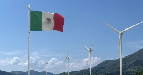 Flag of Mexico flies over a blue sky with a beautiful mountain and wind turbines 動画素材 240956192