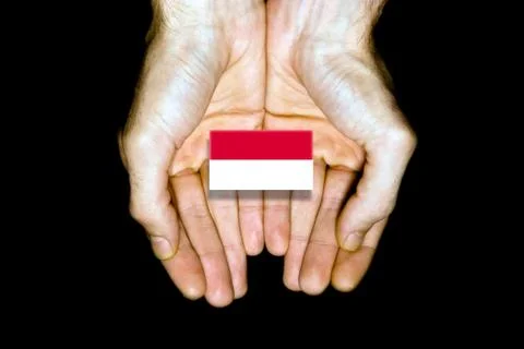 Flag of Monaco in hands on black background Stock Photos