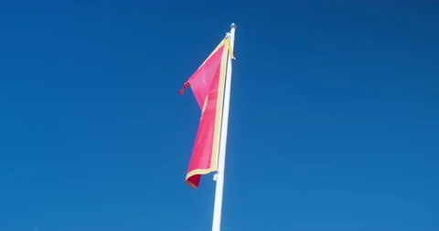 Flag of Montenegro flutters in wind blue sky red canvas gold rim eagle crown Stock Footage 221803892