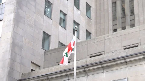 The flag of Montreal behind a building 스톡 동영상 128940977