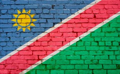 Flag of Namibia painted on brick wall, background texture Stock Photos