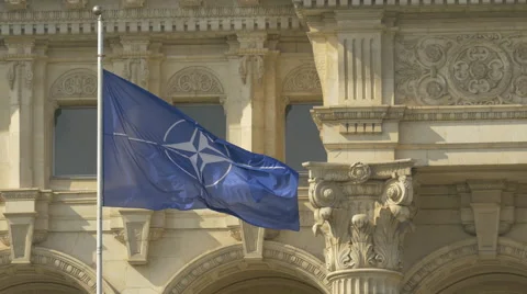 The flag of NATO waving at the Palace of Parliament in Bucharest Stock Footage