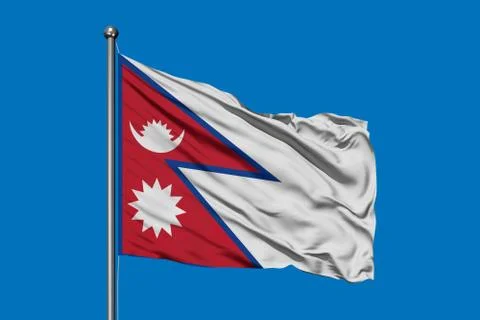 Flag of Nepal waving in the wind against deep blue sky. Nepalese flag. Stock Photos