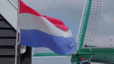 The flag of the Netherlands in front of a windmill Stock Footage