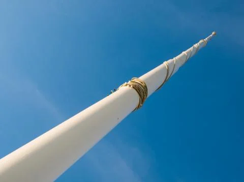 Flag pole pointed at the blue sky seen from below Stock Photos