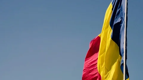 A flag on a pole waving in the sun with clear blue sky Stock Footage 98948958